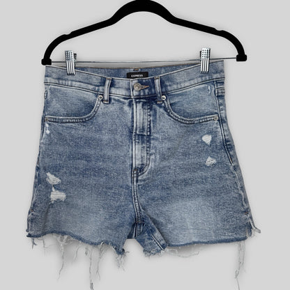 Blue denim shorts with distressed details on a hanger against a white background